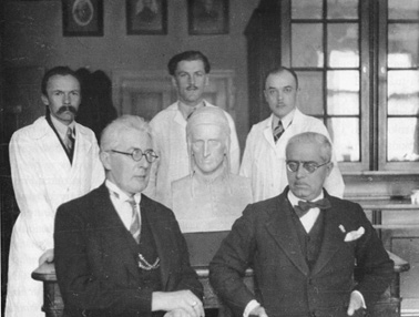 A 1938 group portrait showing Kazimierz Stołyhwo sitting with Professor Fabio Frassetto, in front of a sculpted bust of Dante Alighieri. Three assistants from the Jagiellonian University’s Department of Anthropology—Bronisław Jasicki, Paweł Sikora, and Włodzimierz Nielipiński—stand behind.