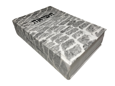 Książka jest ustawiona płasko, widać jej grzbiet wraz z tytułem. Okładka przedstawia kostkę brukową.