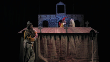 A man standing in front of a table with a puppet on it.