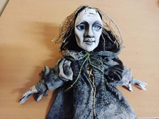 A doll with a green ribbon.