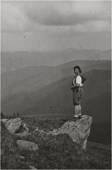 Turystka stoi na skałce na tle gór - Bieszczady. Czarno-biała fotografia.  