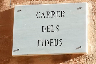 Marble street sign mounted on a wall. 