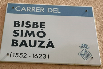 Metal street sign on a wall. 