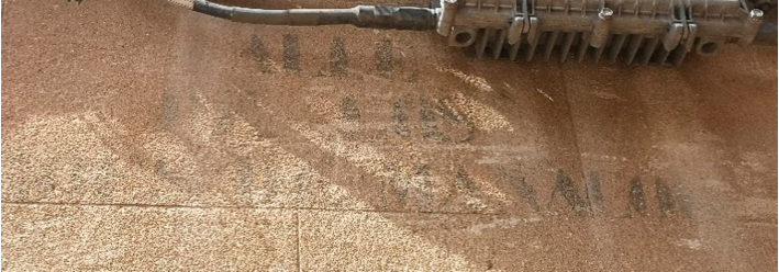 Faded black stencilled lettering on a wall.  