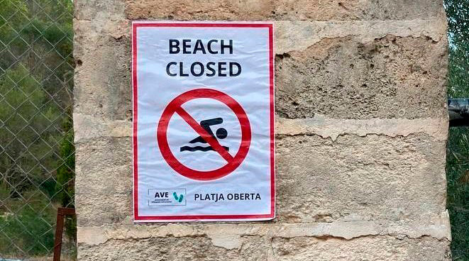 A paper poster pasted onto a brick pillar. 