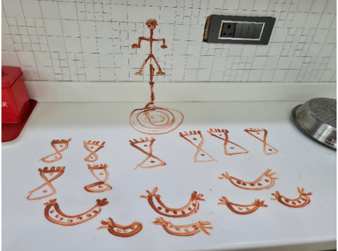 Traditional symbolic drawings made with red ochre on a white tiled wall and counter, depicting Lord Vishnu during Dev Uthan Ekadashi.